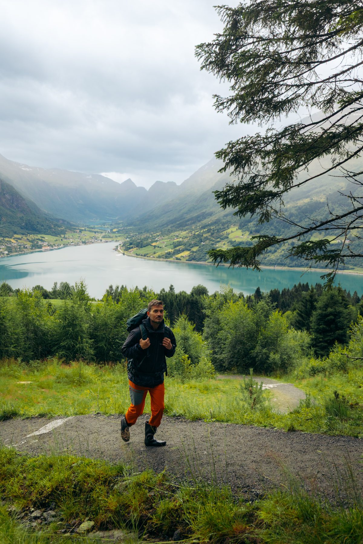 Furkan hiking a gravel trail above a fjord